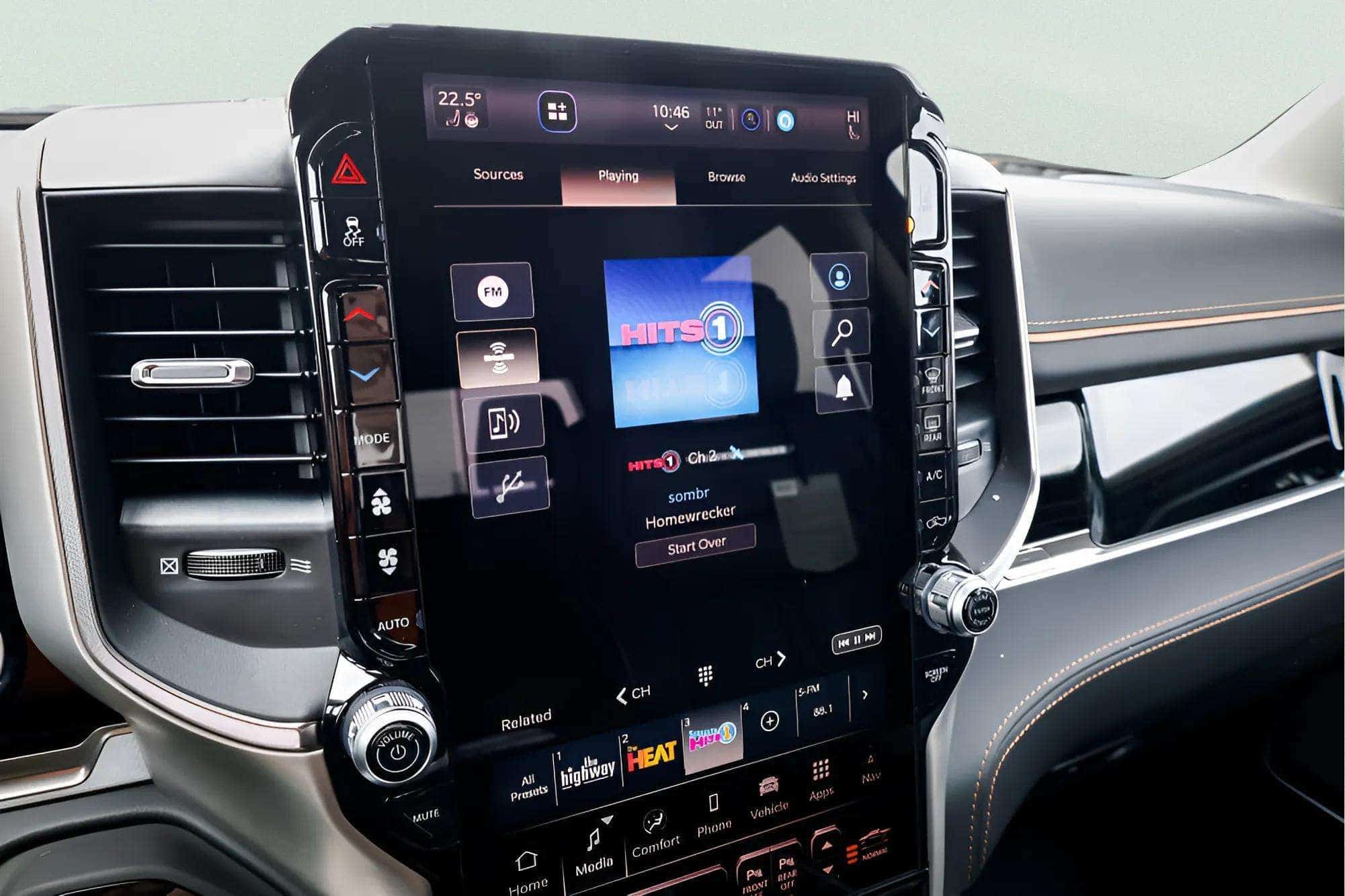 Car dashboard with touchscreen displaying "Hits 1" radio, controls, and climate settings.